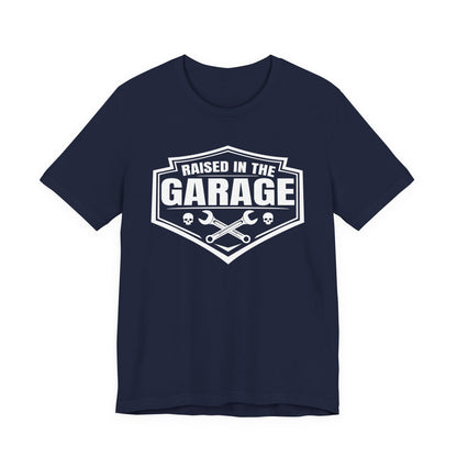 Navy Blue t-shirt with wrenches and skulls with "raised in the garage" text on a white background